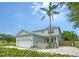Charming two-story home with light blue siding, a white picket fence, and a well-manicured front yard with palm tree at 1738 Siesta Dr, Sarasota, FL 34239