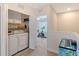 Bright hallway featuring a laundry room with modern appliances, leading to a bonus room with an exercise bike at 1738 Siesta Dr, Sarasota, FL 34239