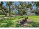 Wooden park bench beneath a large tree with playground in background at 1738 Siesta Dr, Sarasota, FL 34239