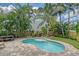 Relaxing backyard with a beautiful pool, lush tropical landscaping, perfect for entertaining and enjoying sunny days at 1738 Siesta Dr, Sarasota, FL 34239
