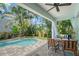 Relaxing backyard with swimming pool, covered patio and tropical landscaping at 1738 Siesta Dr, Sarasota, FL 34239