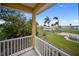 A balcony view overlooking the lush backyard, showcasing the canal beyond the fence at 204 21St Ne St, Bradenton, FL 34208