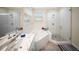 Updated bathroom features a glass shower, soaking tub, tile floors, double sinks, and modern cabinets at 204 21St Ne St, Bradenton, FL 34208