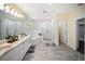Bright bathroom with double sinks, modern fixtures, a glass enclosed shower, and a soaking tub at 204 21St Ne St, Bradenton, FL 34208