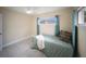 Cozy bedroom with neutral paint, tile floors, a ceiling fan, and a bright window at 204 21St Ne St, Bradenton, FL 34208