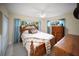 Bedroom with wood furnishings, tiled flooring, a ceiling fan, and window views to the outside at 204 21St Ne St, Bradenton, FL 34208