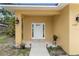 A welcoming covered entrance with a modern white door and decorative wall sconces at 204 21St Ne St, Bradenton, FL 34208