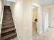 Hallway with wooden stairs that leads to an upper level, with an doorway opening to a room at 204 21St Ne St, Bradenton, FL 34208
