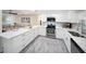 Beautiful open kitchen featuring white cabinetry, stainless steel appliances, and an island with quartz countertops at 204 21St Ne St, Bradenton, FL 34208