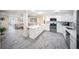 Open concept kitchen with a quartz countertop island, stainless steel appliances, and grey wood-look flooring at 204 21St Ne St, Bradenton, FL 34208