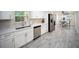 Bright kitchen with white cabinets, quartz countertops, stainless steel appliances, and gray wood-look floors at 204 21St Ne St, Bradenton, FL 34208