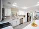 Bright kitchen with white cabinets, stainless steel appliances, a tile backsplash, and gray wood-look floors at 204 21St Ne St, Bradenton, FL 34208