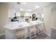 Open concept kitchen with an island with a quartz countertop, stainless steel appliances, and three bar stools at 204 21St Ne St, Bradenton, FL 34208