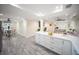 Open concept kitchen with an island with a quartz countertop, grey wood-look flooring, and an adjoining dining area at 204 21St Ne St, Bradenton, FL 34208