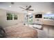 Bright main bedroom features a ceiling fan, outdoor views from windows, and a doorway to the exterior at 204 21St Ne St, Bradenton, FL 34208