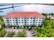Aerial view of a luxury condominium with a red tile roof, lush landscaping, and convenient parking at 210 3Rd W St # 8308, Bradenton, FL 34205