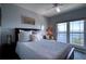 Serene bedroom with a queen-sized bed, stylish accent chair, and scenic waterfront views through a bright window at 210 3Rd W St # 8308, Bradenton, FL 34205