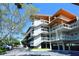 Modern condominium with covered parking, exterior staircases, and lush green landscaping at 225 Sands Point Rd # 6201, Longboat Key, FL 34228