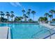 Beautiful community pool area with lounge chairs and views of palm trees near the beach at 225 Sands Point Rd # 6201, Longboat Key, FL 34228