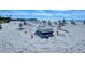 Picturesque beach view with lounge chairs, umbrellas, and playful sand art under a clear, sunny sky at 225 Sands Point Rd # 7205, Longboat Key, FL 34228