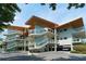 Modern condo exterior featuring glass railings, covered parking, and manicured landscaping at 225 Sands Point Rd # 7205, Longboat Key, FL 34228