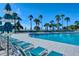 Inviting community pool with lounge chairs and umbrellas overlooking the ocean and surrounded by lush tropical landscaping at 225 Sands Point Rd # 7205, Longboat Key, FL 34228
