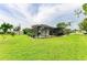 Expansive backyard features a screened-in pool, lush lawn, and mature landscaping at 237 Saxon Cir, Venice, FL 34293