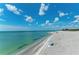 Scenic beach view featuring turquoise water, white sand, sparse beachgoers, and a vibrant blue sky with clouds at 237 Saxon Cir, Venice, FL 34293