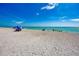 Wide, sandy beach featuring families enjoying a sunny day by the ocean under a blue sky at 237 Saxon Cir, Venice, FL 34293