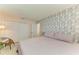 Bedroom with large bed, light pink walls, and accent leaf patterned wall at 237 Saxon Cir, Venice, FL 34293