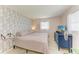 Relaxing bedroom with unique wallpaper, plenty of light, and a classic blue dresser at 237 Saxon Cir, Venice, FL 34293
