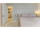 Bedroom with large bed, leaf patterned wall, and adjoining bathroom at 237 Saxon Cir, Venice, FL 34293
