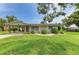 Inviting single-story home with a charming covered carport, colorful plants, and lush lawn at 237 Saxon Cir, Venice, FL 34293