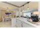 Modern kitchen with a marble countertop, white cabinets and a view of the dining and living area at 237 Saxon Cir, Venice, FL 34293