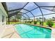 Full in-ground pool with screened cage and ladder entrances is enclosed by trees at 237 Saxon Cir, Venice, FL 34293