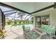 Relaxing screened-in patio with stylish furniture overlooking a sparkling pool and green backyard at 237 Saxon Cir, Venice, FL 34293