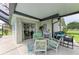 Covered and screened lanai with stylish furniture is next to the yard and pool at 237 Saxon Cir, Venice, FL 34293