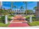 Charming shopping center entrance with red brick walkway, palm trees, and clear blue sky views at 237 Saxon Cir, Venice, FL 34293