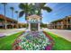 Charming streetscape featuring flowerbeds, palm trees, and a quaint welcome sign at 237 Saxon Cir, Venice, FL 34293