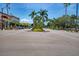 A wide street is lined with shady trees and palms, with a small central garden feature at 237 Saxon Cir, Venice, FL 34293
