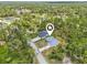 Aerial view of homes in a lush, green neighborhood, close to a waterway, with mature trees at 2523 Hagerick Ln, North Port, FL 34288