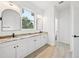 Bright bathroom with double vanity, dual mirrors, and walk-in access at 2523 Hagerick Ln, North Port, FL 34288