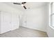 A clean and bright bedroom featuring tile floors, a ceiling fan, a window and closet for storage at 2523 Hagerick Ln, North Port, FL 34288