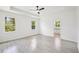Bright bedroom with wood-look tile floors, natural light, and a ceiling fan at 2523 Hagerick Ln, North Port, FL 34288