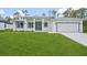 Beautiful new construction home with a well-manicured lawn and clean, modern architecture at 2523 Hagerick Ln, North Port, FL 34288