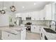 Stylish kitchen featuring white cabinets, stainless appliances, granite countertops, and decorative lighting at 2523 Hagerick Ln, North Port, FL 34288