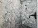 Modern shower with floor-to-ceiling marble tile and black hardware at 2523 Hagerick Ln, North Port, FL 34288