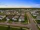 Aerial view of a suburban neighborhood with paved streets, manicured lawns, and homes with gray roofs at 2586 Wild Cherry Path, Sarasota, FL 34240