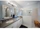 Modern bathroom featuring dual sinks, granite countertop, and a frameless glass shower at 2586 Wild Cherry Path, Sarasota, FL 34240