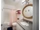 Stylish bathroom with rope mirror, walk-in shower, and modern vanity at 2586 Wild Cherry Path, Sarasota, FL 34240